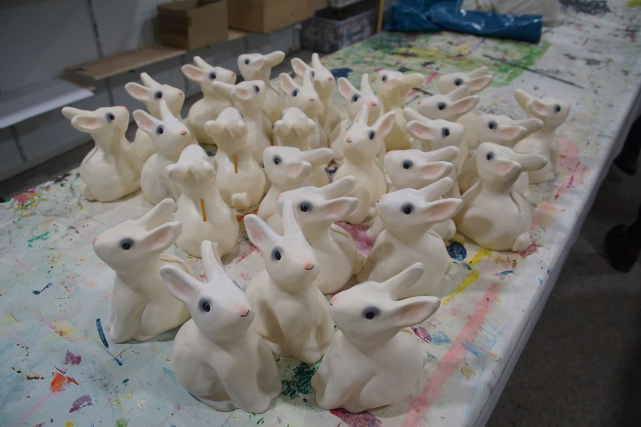 White plastic rabbits on a colourful table